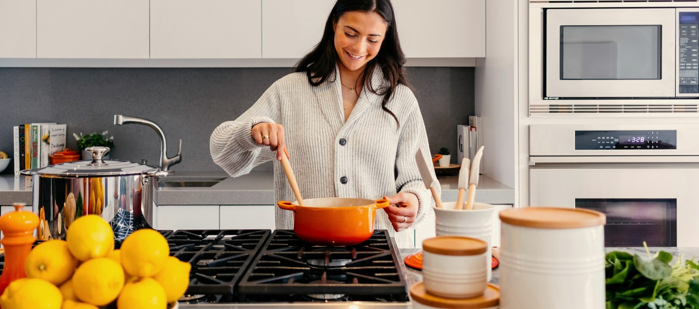 A woman cooking dinner at home in a bright, warm kitchen