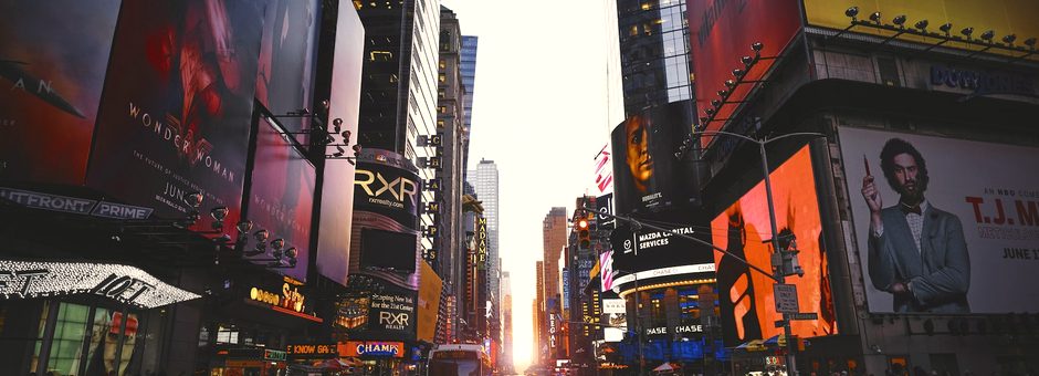 A city street crowded with glowing billboards and video screens